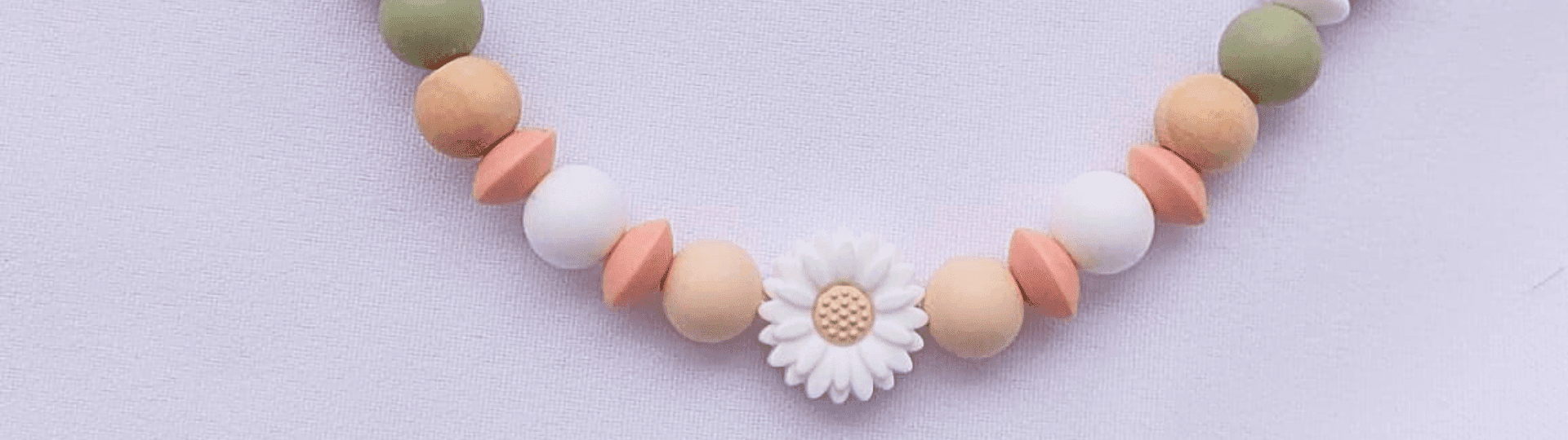 Acesorio para chupete de bebe con colores de montaña y flor, hecho a manos en Reus.